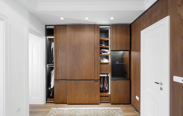 Intérieur moderne avec meuble de rangement bas en bois aux tiroirs colorés jaunes et orange, posé sur parquet